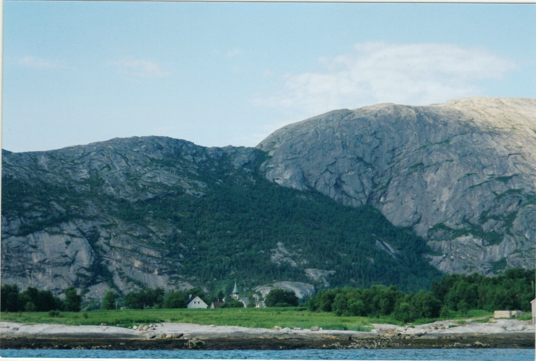 Photo showing part of Rørstad in Sørfold. The church can barely be seen, it it a woodden cross-church from 1761